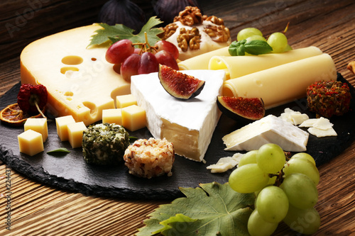 Cheese platter with different cheese and grapes.