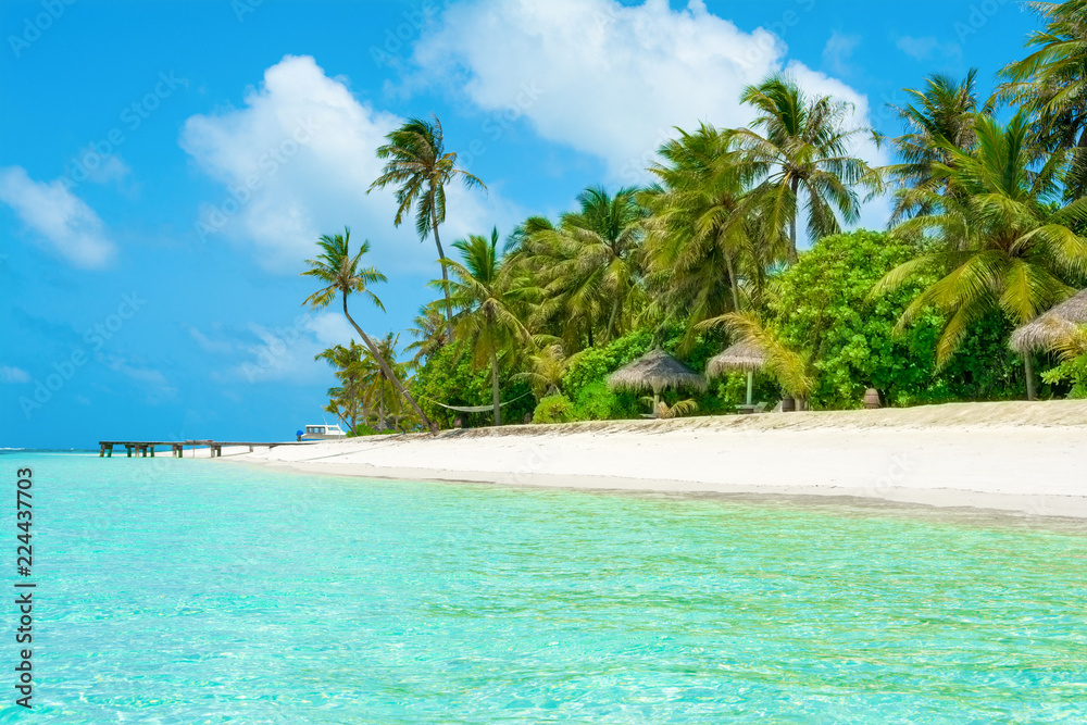 Beautiful sandy beach with sunbeds and umbrellas in Indian ocean, Maldives island