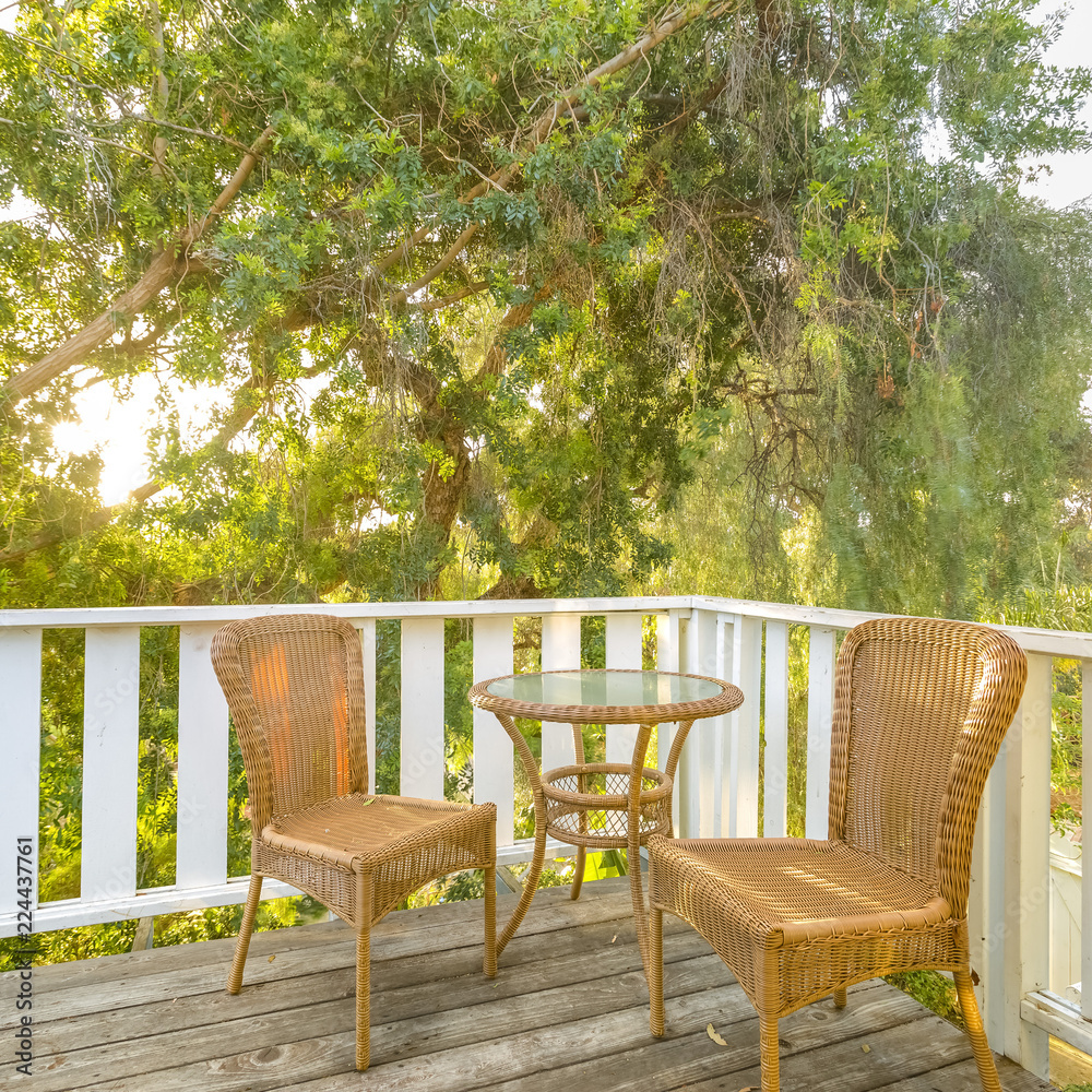 Sunlit balcony with wooven chairs and table Sunlit balcony with wooven chairs and table