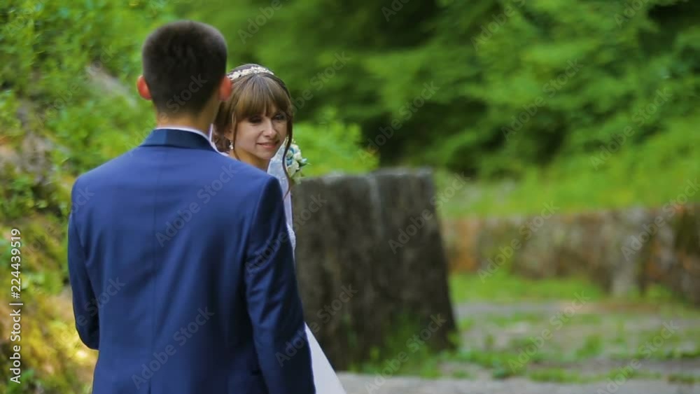 Bride and groom in love looking at each other at beautiful green forest Bride and groom in love looking at each other at beautiful green forest