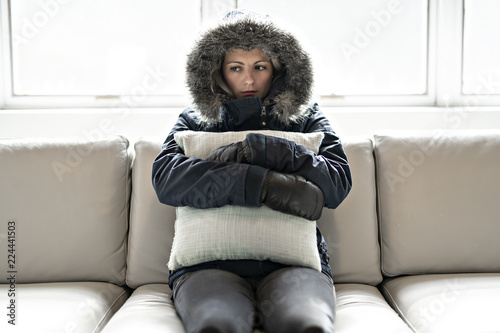 Фотография Woman have flu on the sofa at home with winter coat and pillow
