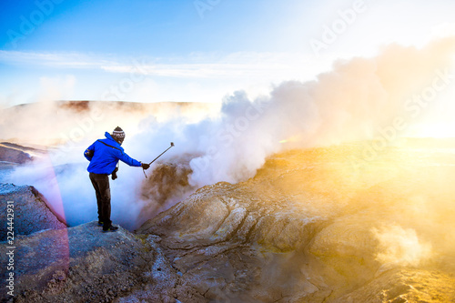 Homme prenant un selfie avec paysage geyser au lever du soleil en Bolivie photo