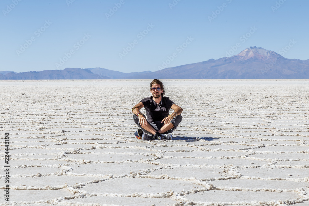 Homme assis dans le désert de sel de Uyuni en Bolivie Paysage voyage aventure