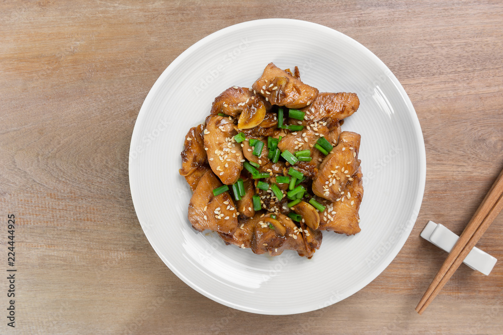 top view of stir fried chicken with black soy sauce in a ceramic dish on wooden table. asian homemade style food concept. top view of stir fried chicken with black soy sauce in a ceramic dish on wooden table. asian homemade style food concept.