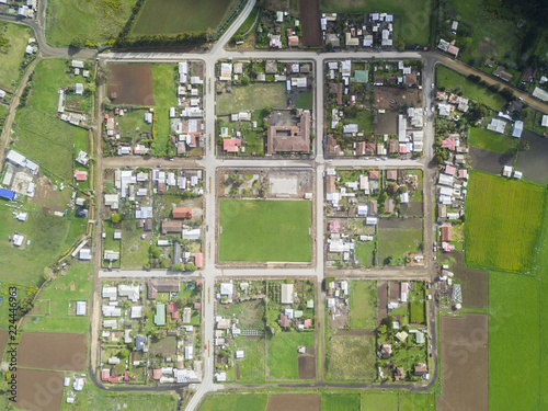 An aerial view of Chile countryside from the drone, a small grass football field as the Main Square inside a new and symmetrical urban planning of the streets in the town of Buchupureo, Chile photo