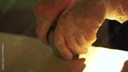 Fingers modeling a clay vessel photo