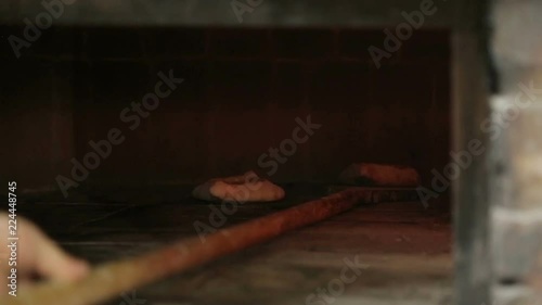 Cook sends khachapuri to oven and takes out freshly baked, traditional cuisine photo