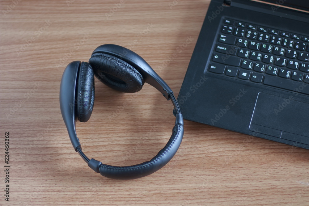 Headphone black notebook on a wooden table. Headphone black notebook on a wooden table.