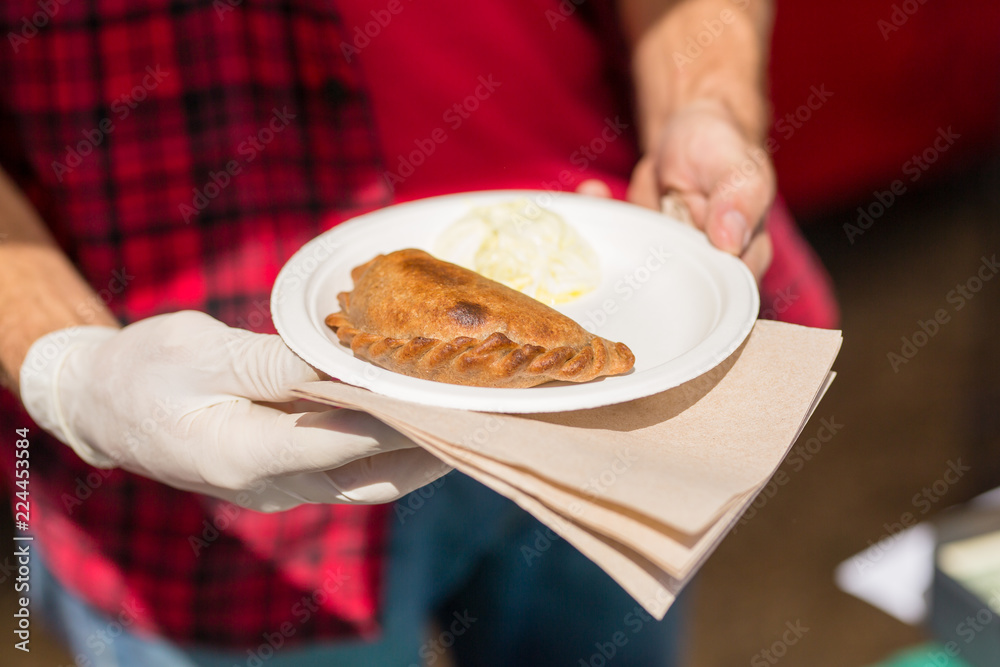 Empanada served on a plate by a man