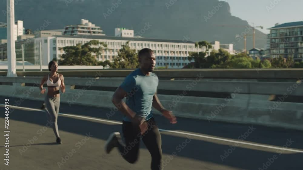 strong muscular man athlete running overtaking runners in competitive race competition on sprinting on urban city road at sunrise