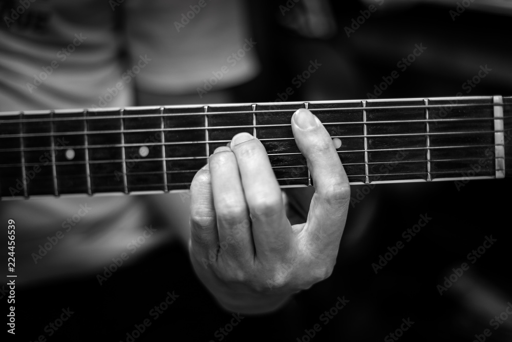 Guitarist playing the guitar, fingles press cord on the fretboard
