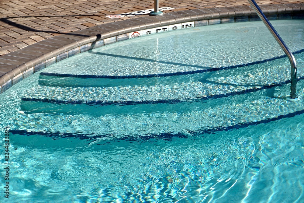 Steps and handrail leading into the low end of a hotel swimming pool