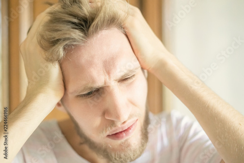close up portrait of young bearded person suffering from strong headache f