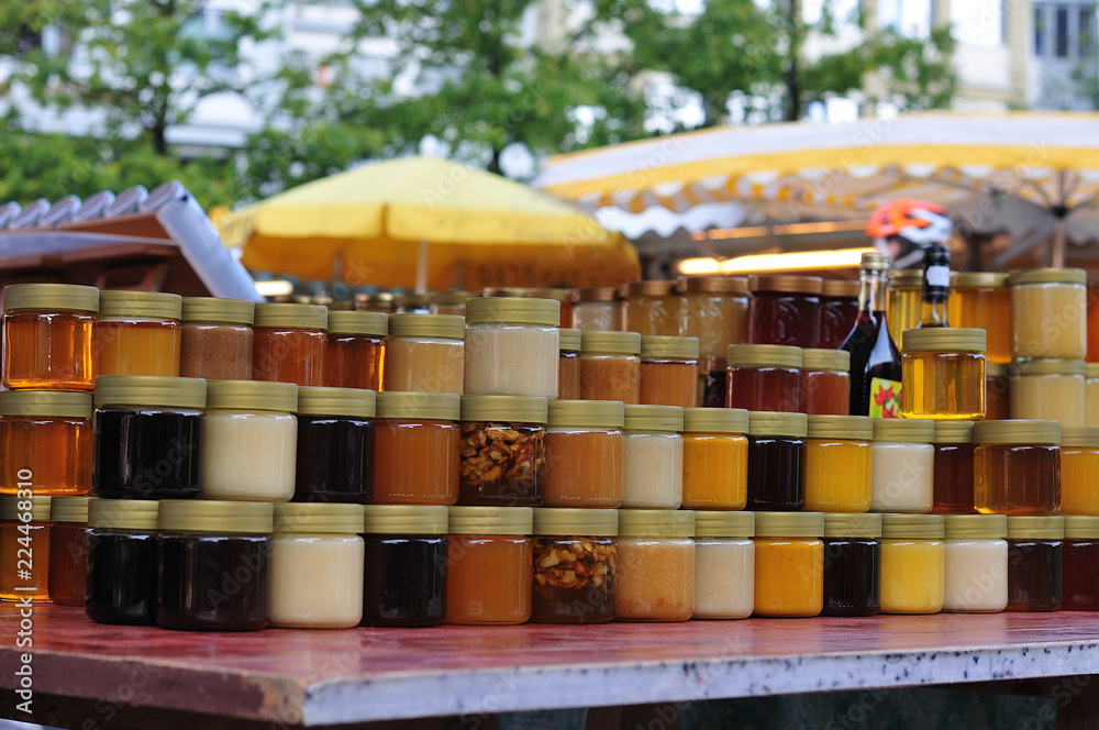 glass containers with honey at market stall