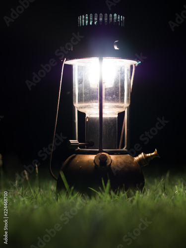 Ancient lamps illuminated with oil on the grass at night.
