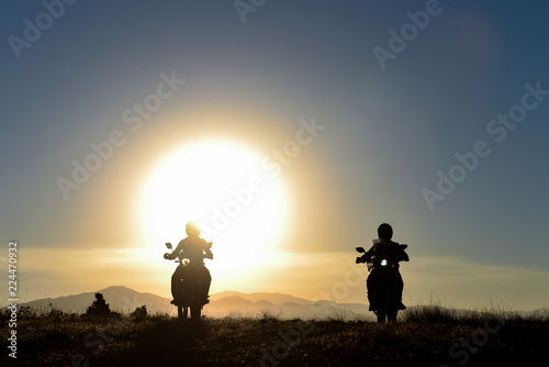 motorcyclists traveling at sunrise time