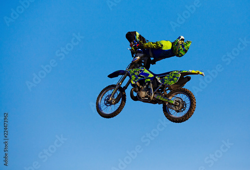 Pro motocross rider riding fmx motorbike  jumping performing extreme stunt. Professional biker jumps
