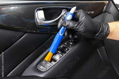 A man cleaning car with microfiber cloth and brush. Car detailing. Valeting concept. Selective focus. Car detailing. Cleaning with brush. Worker cleaning. Brush and cleaning solution to clean.