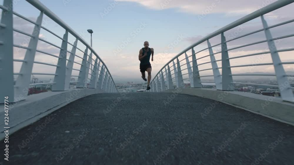 muscular young man running athlete sprinting fast intense workout challenge training endurance in urban city