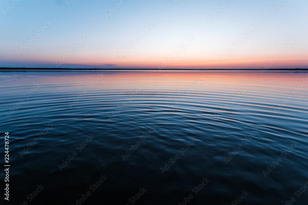 Obraz premium ircles on the water against a beautiful, pink sunset. The magic time of day.