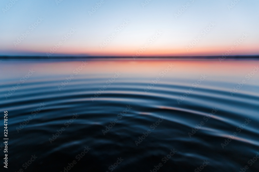 Obraz premium ircles on the water against a beautiful, pink sunset. The magic time of day.
