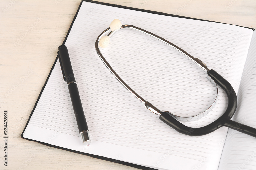 Blank notebook page on doctor desk table with stethoscope Blank notebook page on doctor desk table with stethoscope