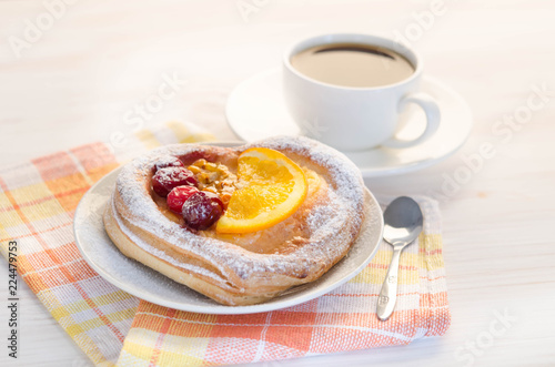 puff  cake  decorate with different fruit with cup of coffee on white table