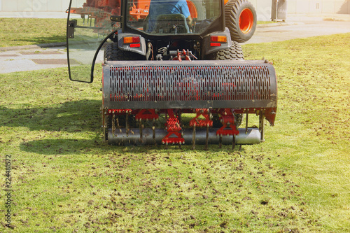 Gardener Operating Soil Aeration Machine on Grass Lawn