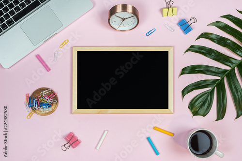 Feminine desk workspace with chalkboard mockup on pink background. Flat lay, top view.