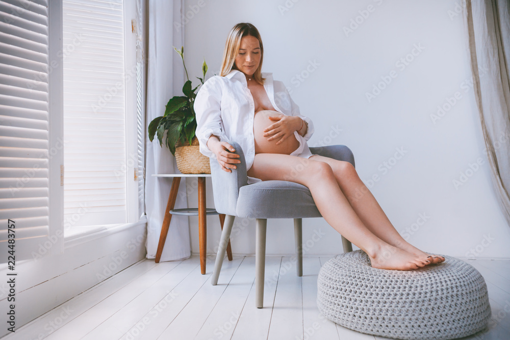 Pregnant mothercare lifestyle concept, blond Bob hairstyle woman health care. white light interior