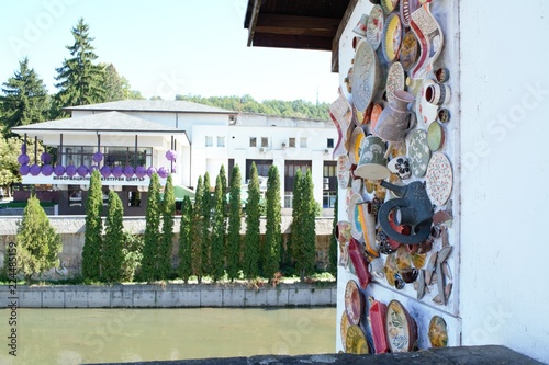 Landscape from Troyan with a wall of handmade dishes and pots as a decoration and the river, crossing the city