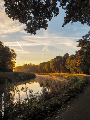 Gorgeous sunrise over the river Dyle near Mechelen, Belgium, during an early misty morning in September photo