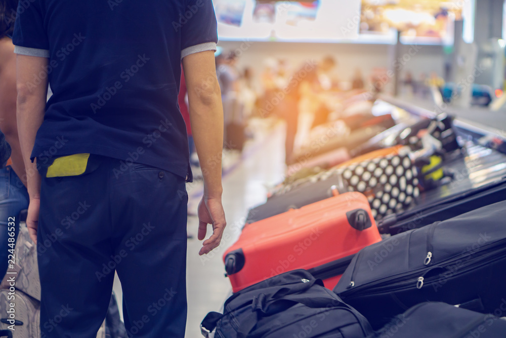 traveler waiting for luggage at Point of checking the scanner After traveling by plane . Baggage X-ray machine band on the conveyor belt at the airport counter background, Business travel concept traveler waiting for luggage at Point of checking the scanner After traveling by plane . Baggage X-ray machine band on the conveyor belt at the airport counter background, Business travel concept