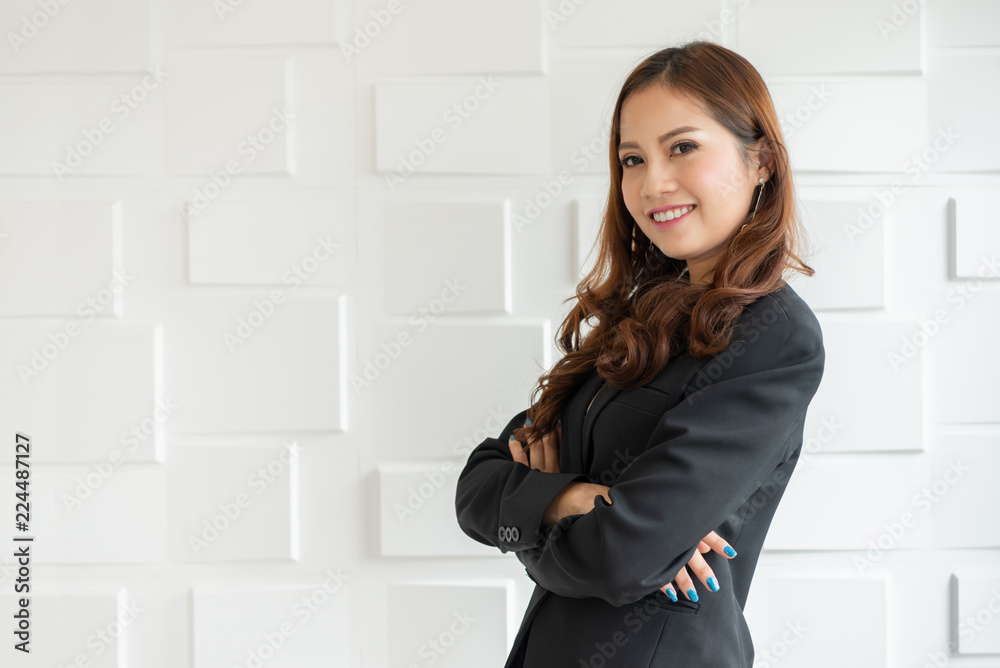Portrait of a confident Asian business woman standing over white wall. Portrait of a confident Asian business woman standing over white wall.