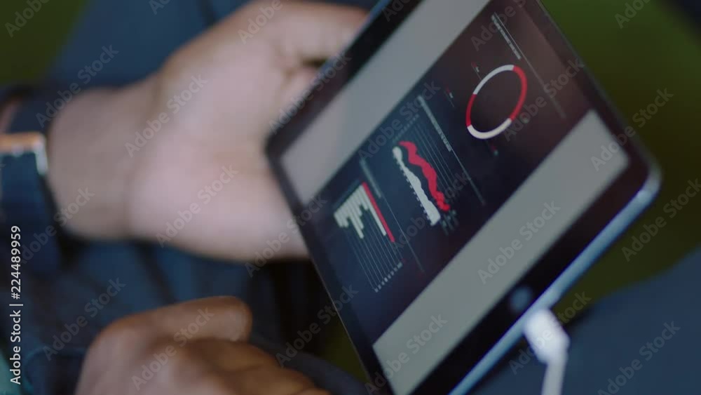 businessman using tablet computer browsing graph research data working on business project enjoying creative brainstorming  viewing mobile device screen in office close up