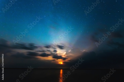 A lighting bolt striking from bright clouds in the night. Belarus. The starry sky.