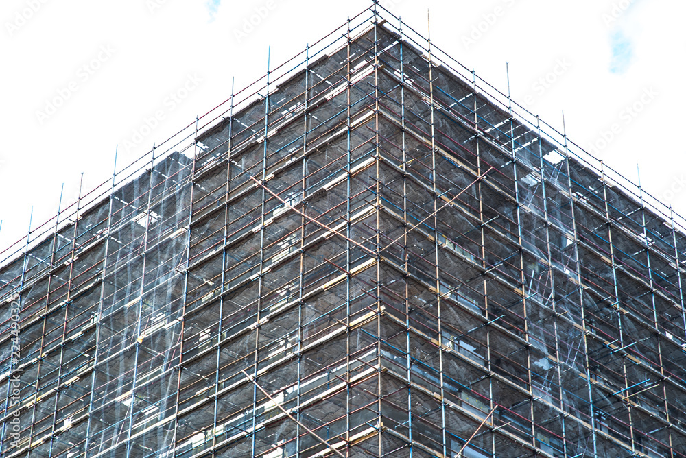 Building apartments under construction on a sunny day. Monochrome toning. Building apartments under construction on a sunny day. Monochrome toning.