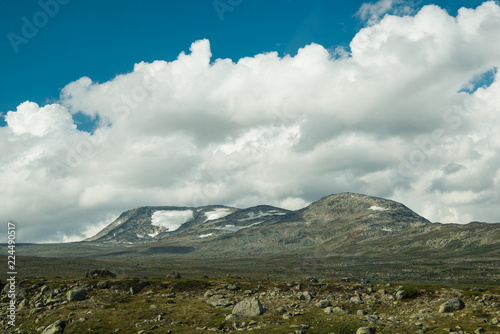 distant view of mountains covered by snow under cloudy sky, Hallingskarvet National park, Norway photo