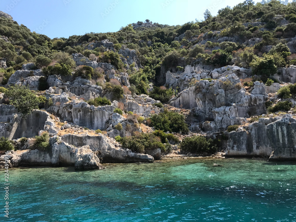 Kayakoy Kekova(Simena) village,Fethiye,Mugla Sunken city of Kekova in bay of Ucagiz view from sea in Antalya province of Turkey with turqouise sea rocks and green bushes with remains of ancient city