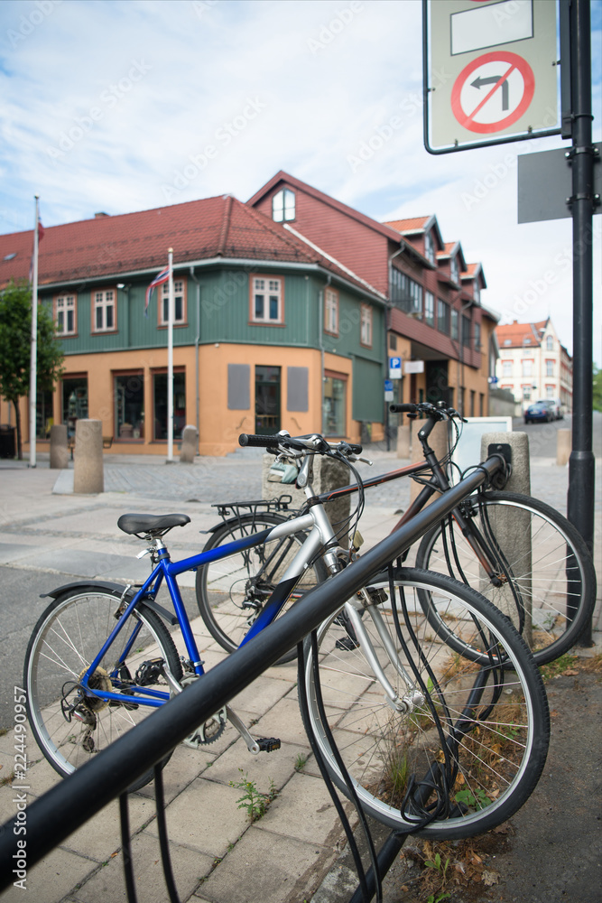 parked bicycles with building behind at city street, Hamar, Hedmark, Norway