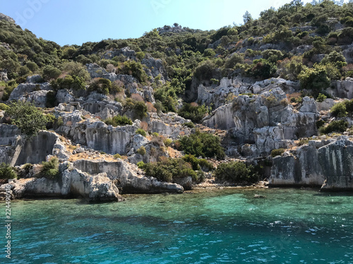Kayakoy Kekova(Simena) village,Fethiye,Mugla Sunken city of Kekova in bay of Ucagiz view from sea in Antalya province of Turkey with turqouise sea rocks and green bushes with remains of ancient city © Alp Aksoy