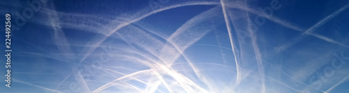 Chemtrails und Dunststreifen am blauen Himmel 