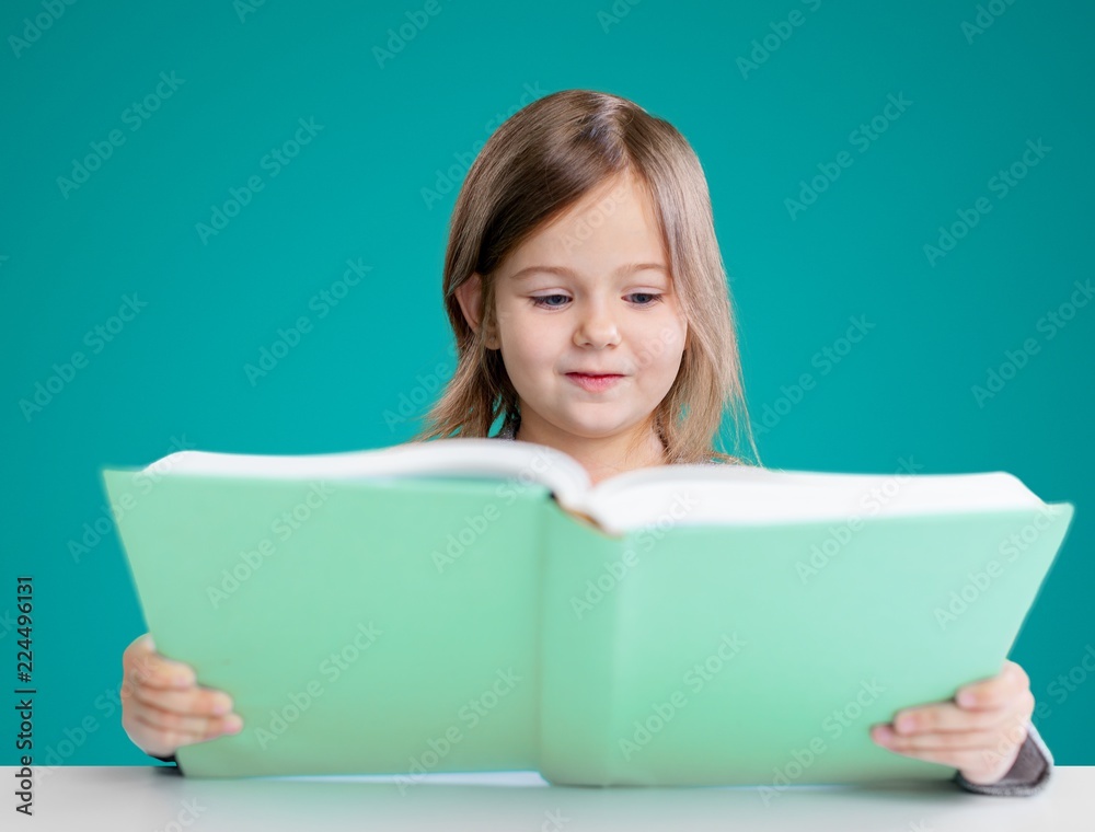 Adorable young girl reading a book Adorable young girl reading a book