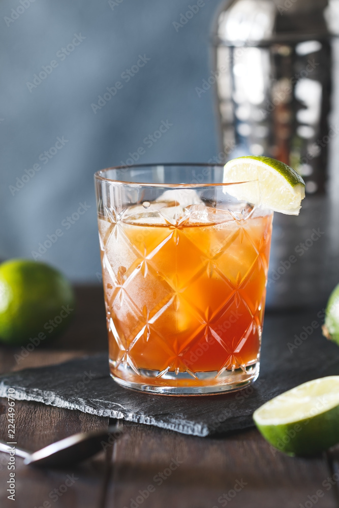 Fototapeta premium The alcoholic Surfer on Acid cocktail in a old-fashioned glass with a lime wedge.