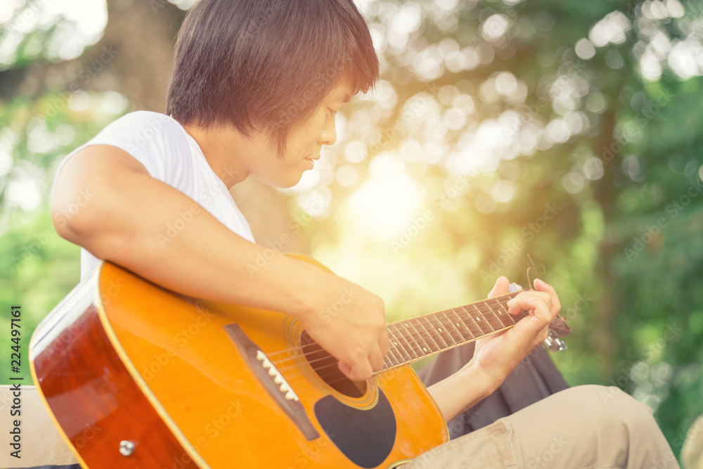 Fototapeta premium The guy playing the guitar, outdoor, cargo pants