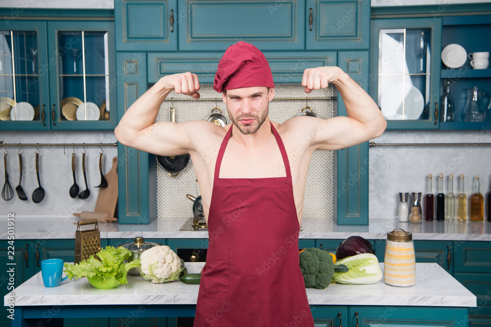 Sexy muscular chef in front of kitchen. Attractive chef ready to cook.  Muscular chef posing in