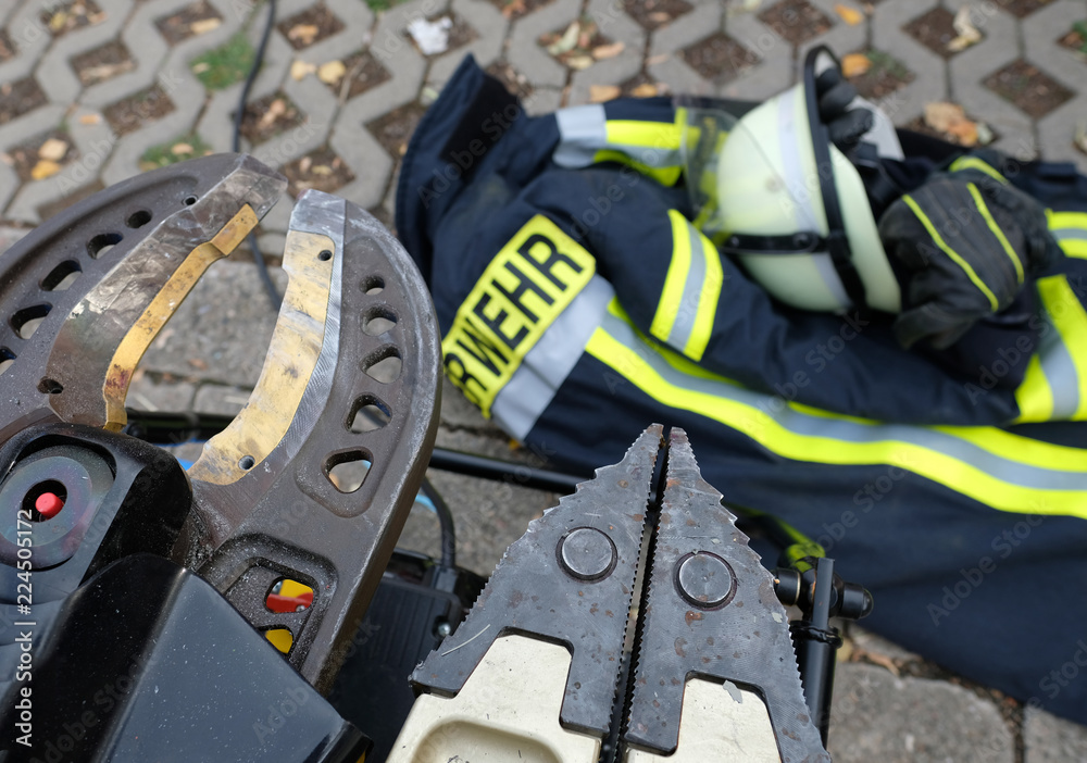 Fototapeta premium Pneumatische Scheren mit einer Feuerwehrweste im Hintergrund