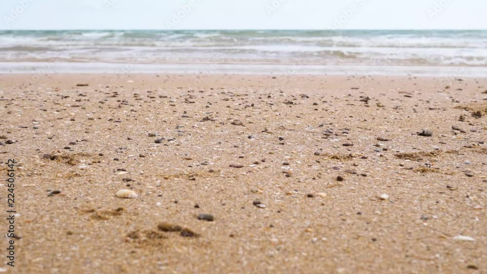 Landscape of calm sea with sand beach and cloudy blue sky. Waves hitting the beach with horizontal line Landscape of calm sea with sand beach and cloudy blue sky. Waves hitting the beach with horizontal line