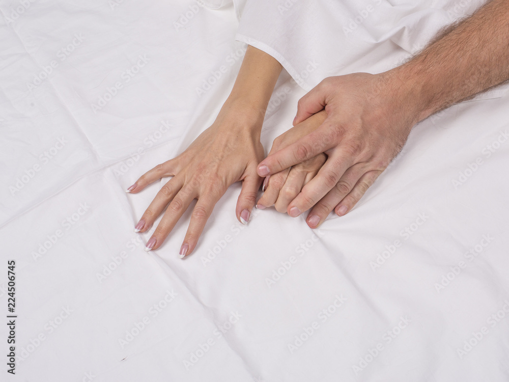 hands of couple having sex pulling white sheets in lust and orgasm hands of couple having sex pulling white sheets in lust and orgasm