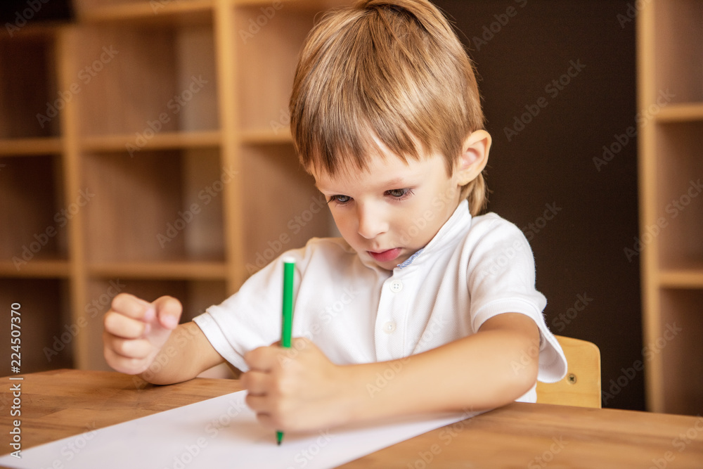 adorable boy drawing with green felt tip pen in kindergarten adorable boy drawing with green felt tip pen in kindergarten
